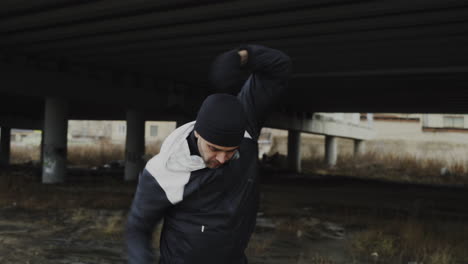 man exercising under a bridge in urban environment