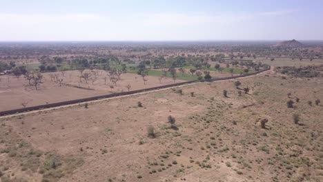 Hermoso-Paisaje-De-Vastas-Tierras-Yermas-En-Rajasthan,-India-Bajo-La-Luz-Del-Sol-Caliente---Antena