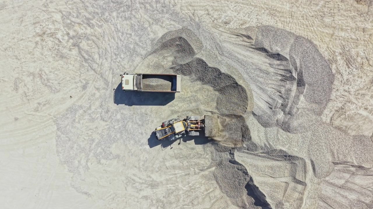 Granite quarry operation with heavy machinery working on stone extraction in open area during daylight