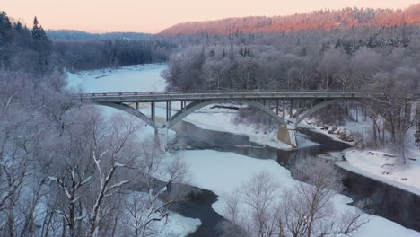 paso sobre un río congelado cruzado por un puente en una mañana de invierno