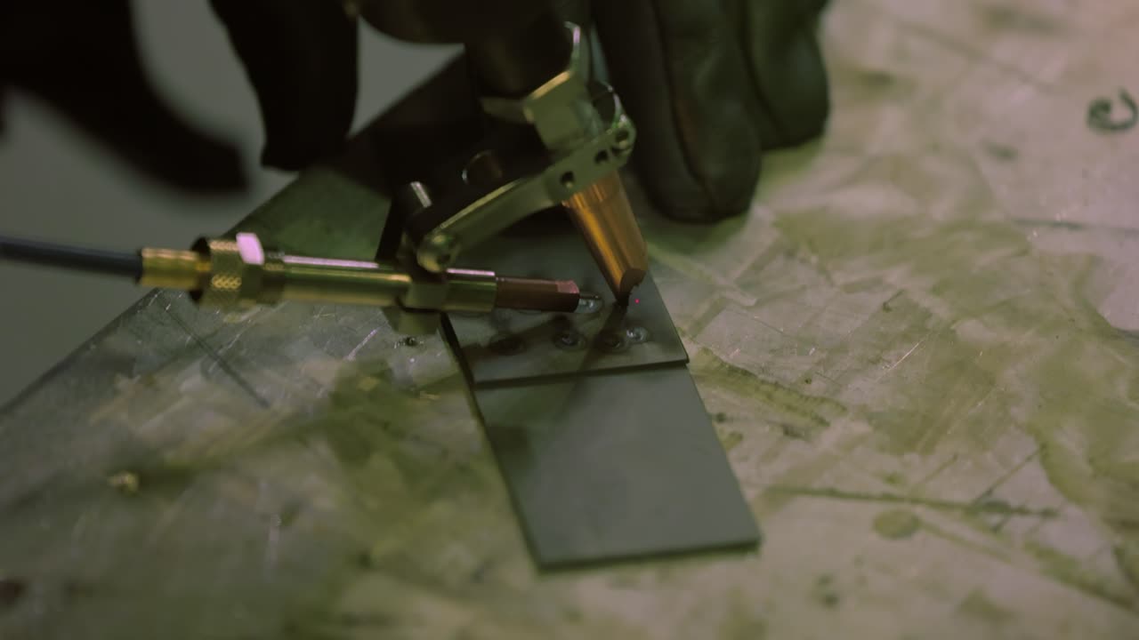 Laser welding machine with hand hold gun. Laser welding is shown in close-up.