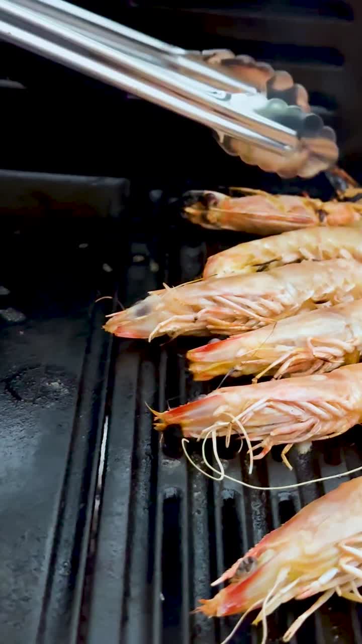camarones siendo asados con pinzas en la barbacoa
