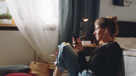 woman using phone on floor in bedroom