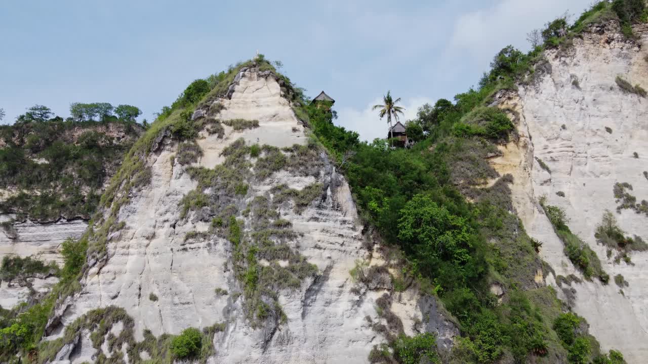 las cabañas de la casa del árbol de rumah en el acantilado empinado de la orilla del océano en nusa penida, aérea