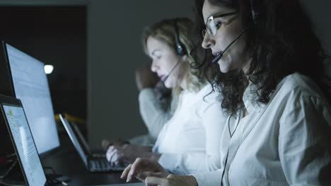 Male-and-female-teleworkers-in-dark-office