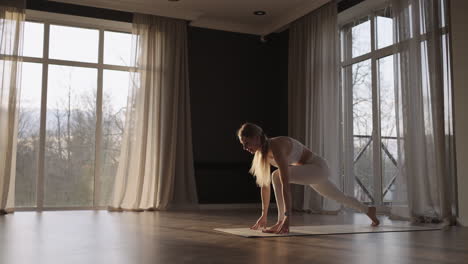 Eine-Junge-Frau-Im-Weißen-Anzug-Trainiert-In-Einem-Fitnessstudio-In-Zeitlupe-Yoga-In-Der-Sonne