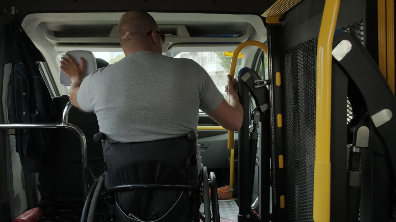 Man in wheelchair in the special the vehicle. The disabled person is transported in a special car. Transportation of disabled people in a special car, bus.