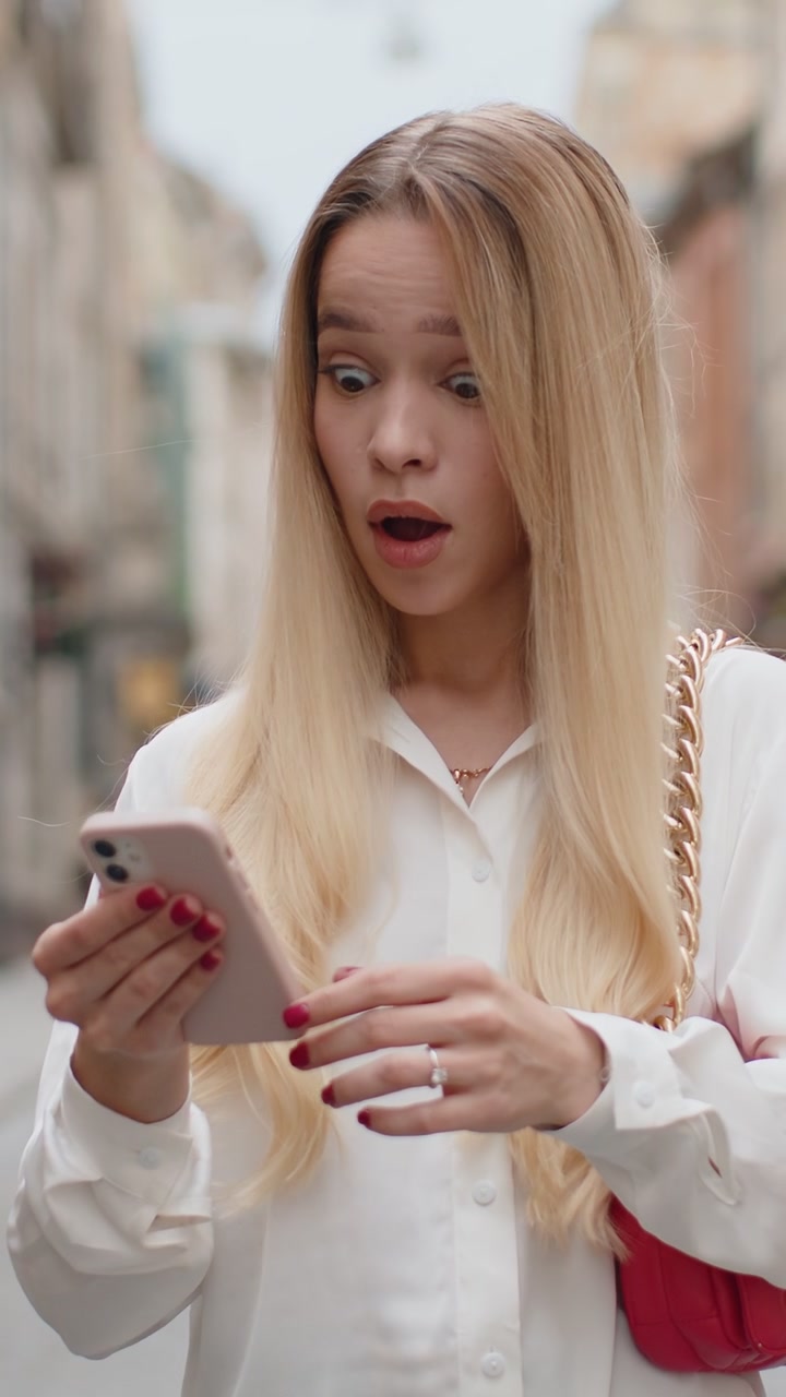 Sorpresa giovane donna usa smartphone perde cattive notizie perdita di fortuna fallisce all'aperto in strada della città