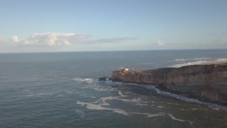 an iconic place on the atlantic coast, the mecca of big-wave surfing. view of nazare's lighthouse in zon north canyon, place with the biggest waves in europe, nazare, portugal