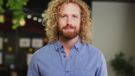 Portrait-of-happy-caucasian-businessman-looking-at-camera-at-office