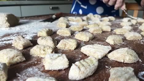 caucasian hands cook gnocchi italian pasta fresh dough kitchen preparation closeup slow motion shot