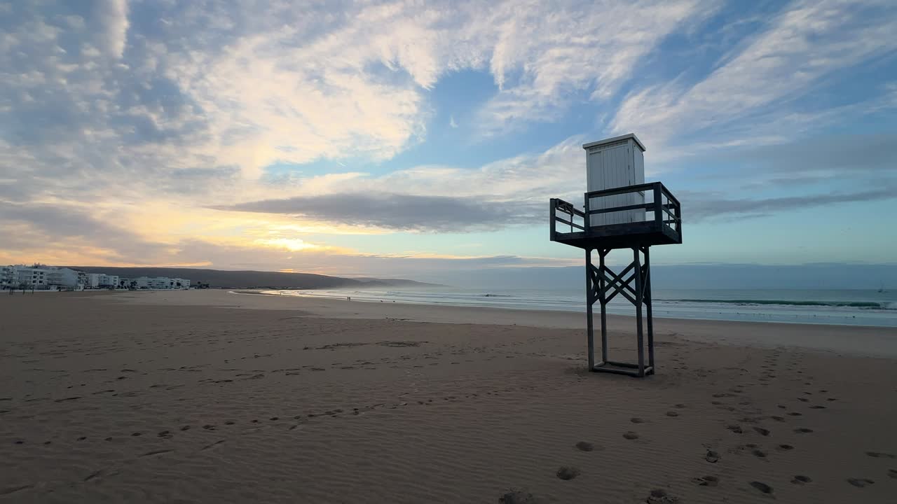 A wide, expansive shot of a pristine beach on a beautiful sunny morning, showcasing clear skies