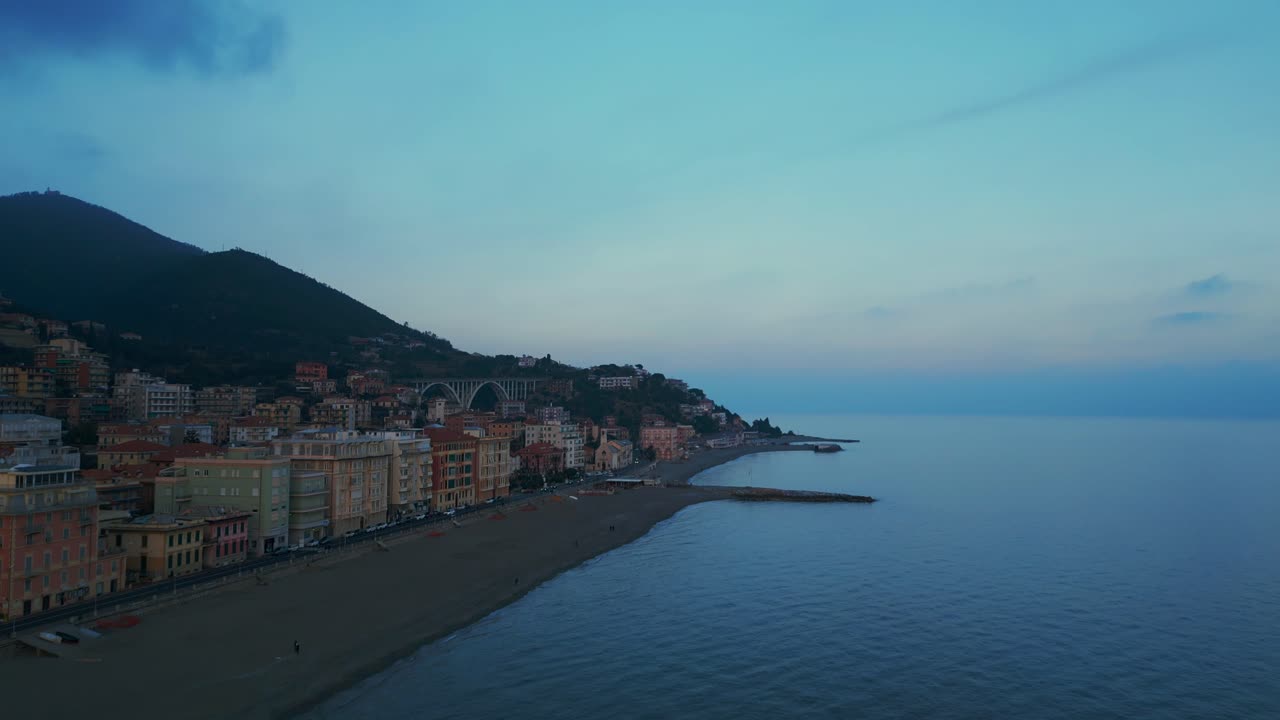 Veduta aerea della spiaggia di Varazze con edifici colorati durante l'ora blu