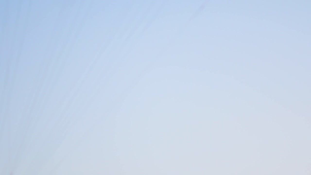 여자와 남자 조종사와 함께 모터 패러글라이더가 땅 위를 날아서 지평선의 거리로 날아갑니다.