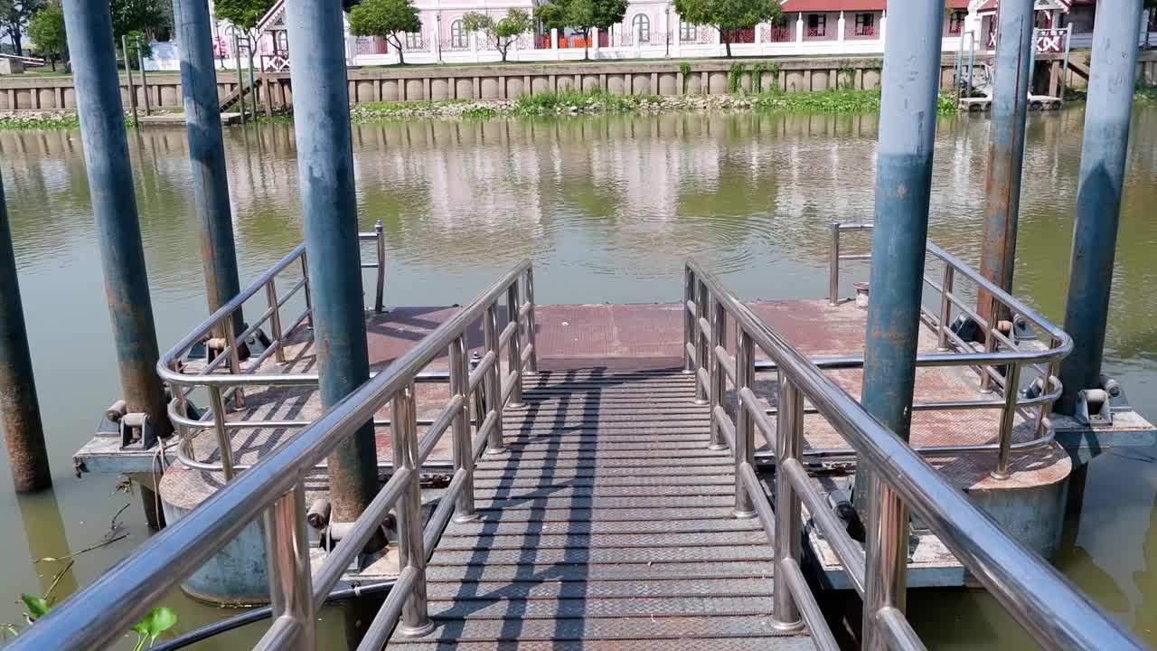 muelle que se extiende hacia el río con casas visibles