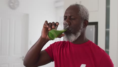 senior african american man drinking fruit and vegetable health drink at home