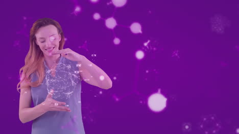 animación de una mujer caucásica que presenta un modelo de globo con moléculas flotando sobre un fondo púrpura