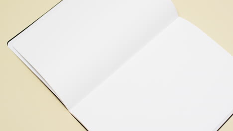 video of book with white blank pages and copy space on yellow background