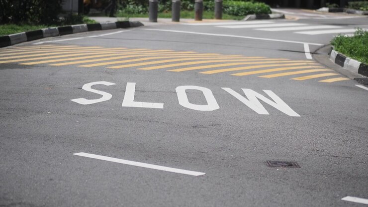 Slow Sign Painted on Asphalt Road Surface