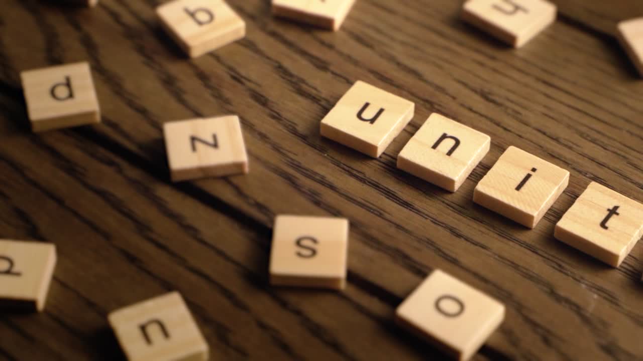 Wooden tiles spell out unity as the camera pans smoothly across a rustic wooden surface with warm tones.