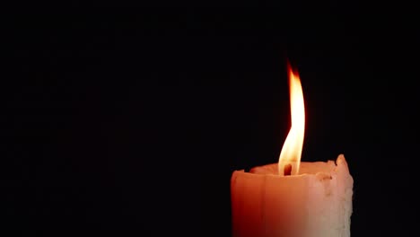 The-showcases-of-colorful-single-candlelight-on-black-background-with-the-effect-of-light-and-slow-motion