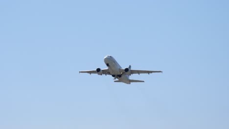 belly view overflying airplane retracting landing gear after takeoff