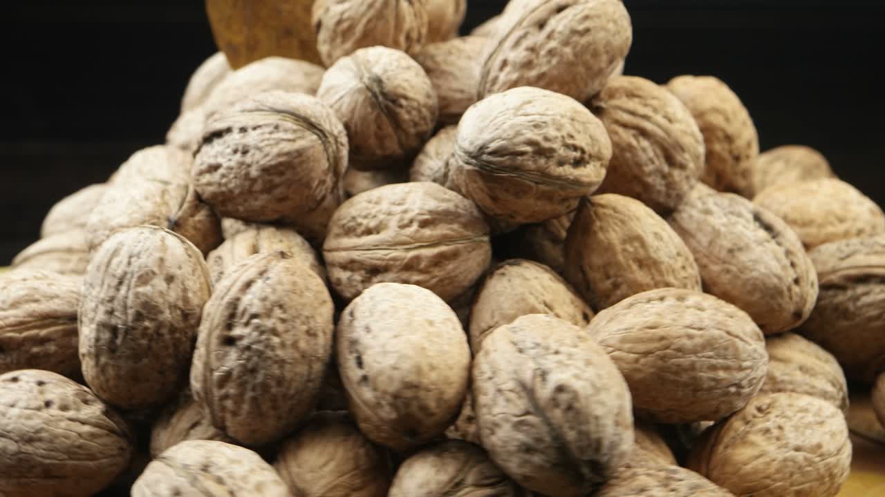 A pile of walnuts lies on a board
