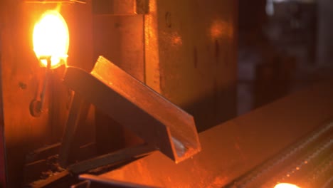 glowing detail from molten metal moving on conveyor line at metallurgy plant