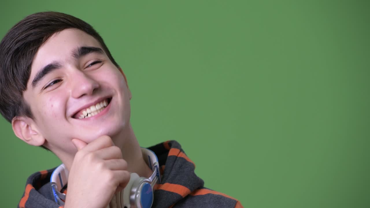 초록색 배경에 젊은 잘생긴 이란 십대 소년