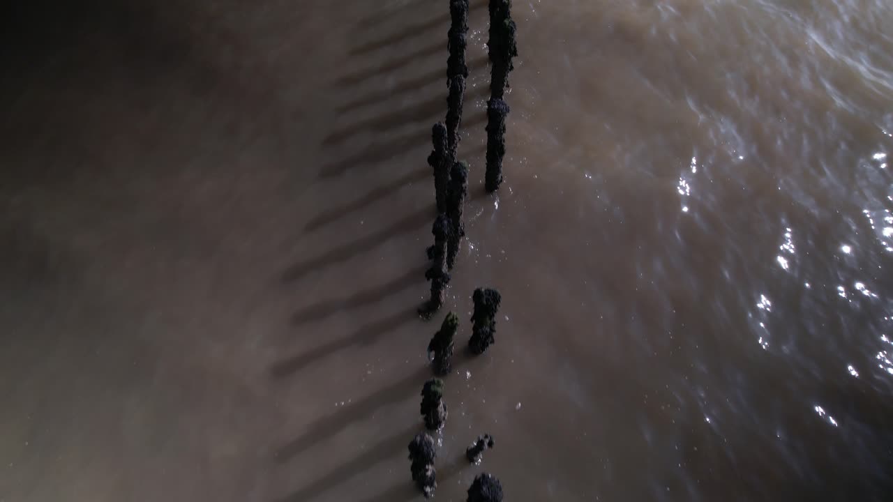 Overhead drone view of posts in sea River blackwater old fish traps