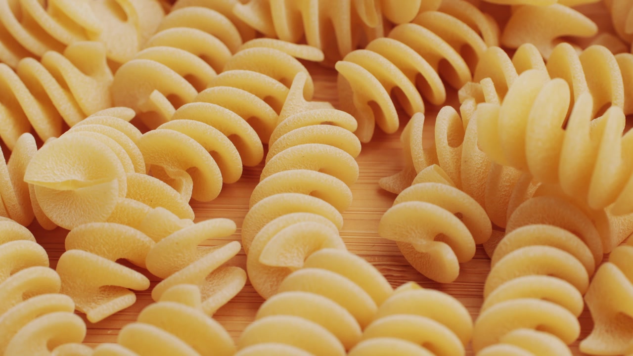 Primo piano di fusilli crudi su una superficie di legno