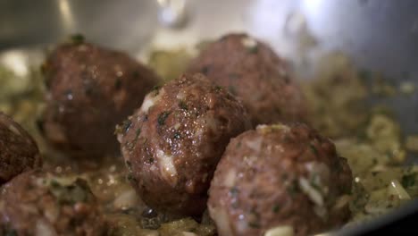 close up of meatballs cooking in pan preparing ingredients to make vegan beyond meatballs with spaghetti and meat sauce