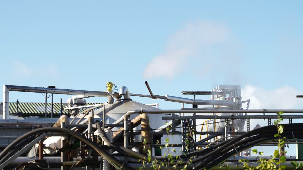 Industrial chemical plant with metal pipes and exhaust releasing gas in the UK