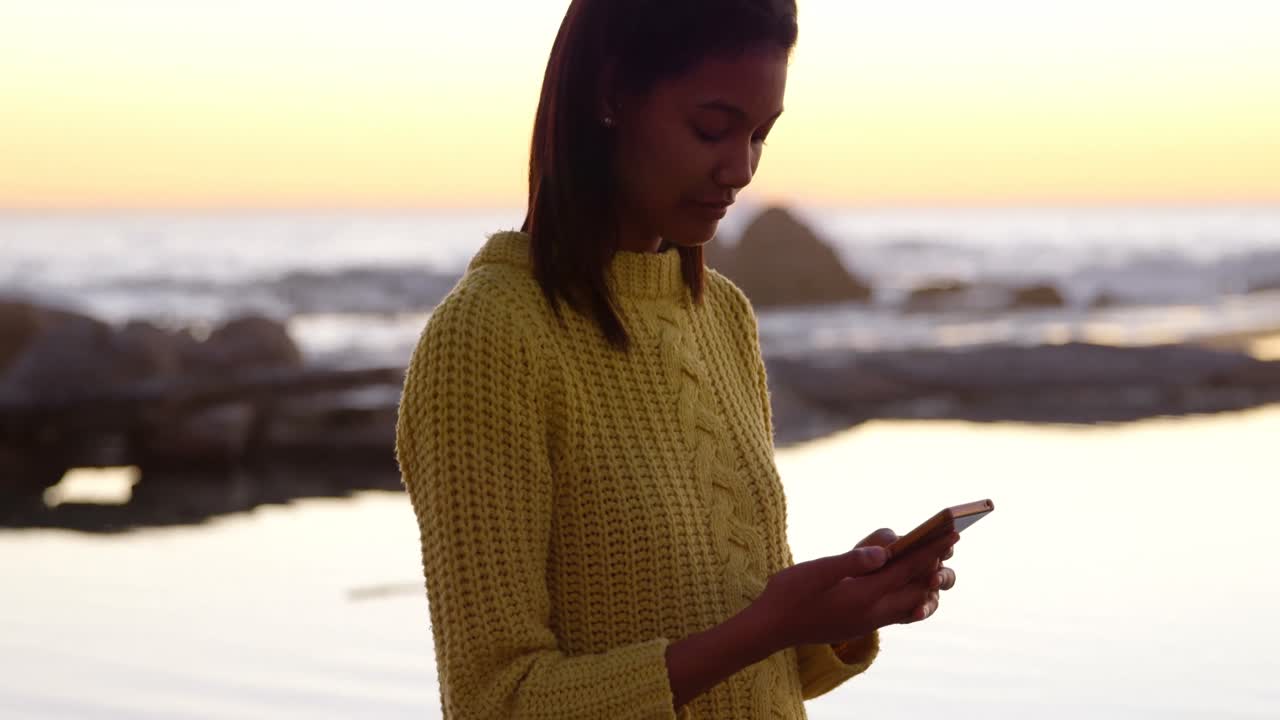 Woman using mobile phone on the beach 4k