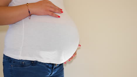 massive belly with a baby inside of young mother, side static view