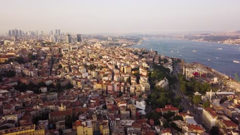 aerial flying over istanbul city at golden hour, bosphorus strait on right side