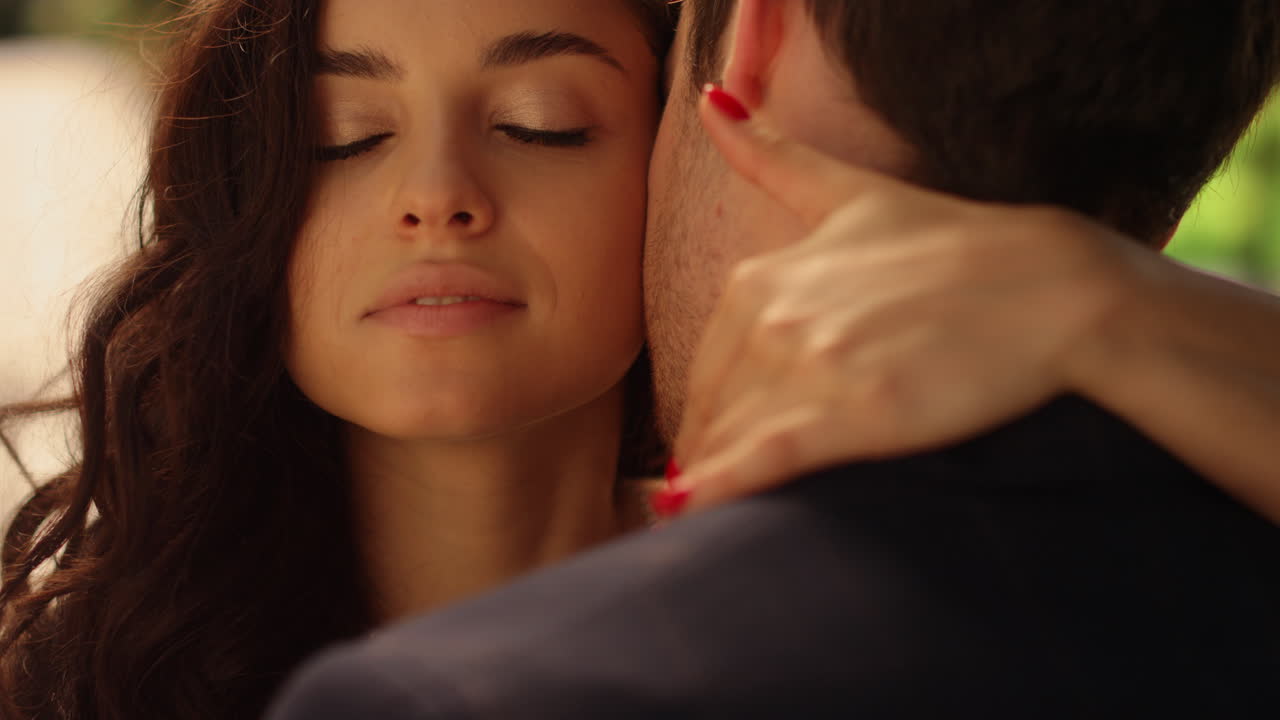 una novia atractiva abrazando al novio en la boda en el jardín. una pareja de pie en el parque