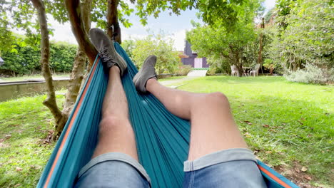 young caucasian man chill and swing in hammock to unwind in nature