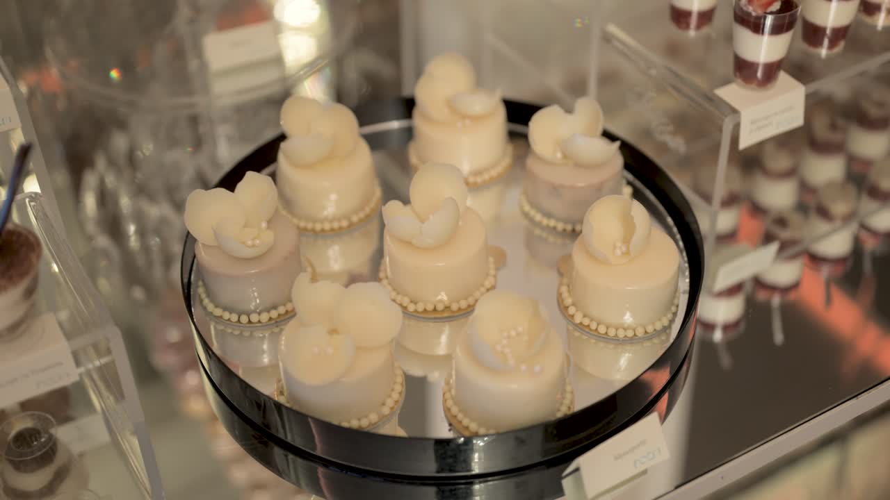 Plate filled with elegant white sweets, delicately arranged as part of a candy bar setup, close up shot
