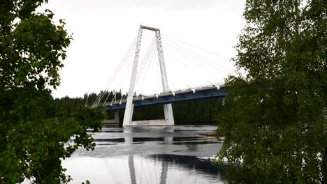 Filmsequenz-Eines-Vogels,-Der-In-Zeitlupe-Vorbeifliegt,-Während-Ein-Einzelnes-Auto-über-Eine-Kabelbrücke-Im-Verlassenen-Nordschweden-Fährt