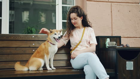 woman and her dog relaxing at an outdoor cafe