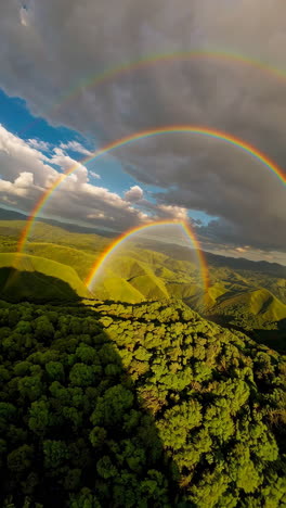 double rainbow over a mountain valley with forest