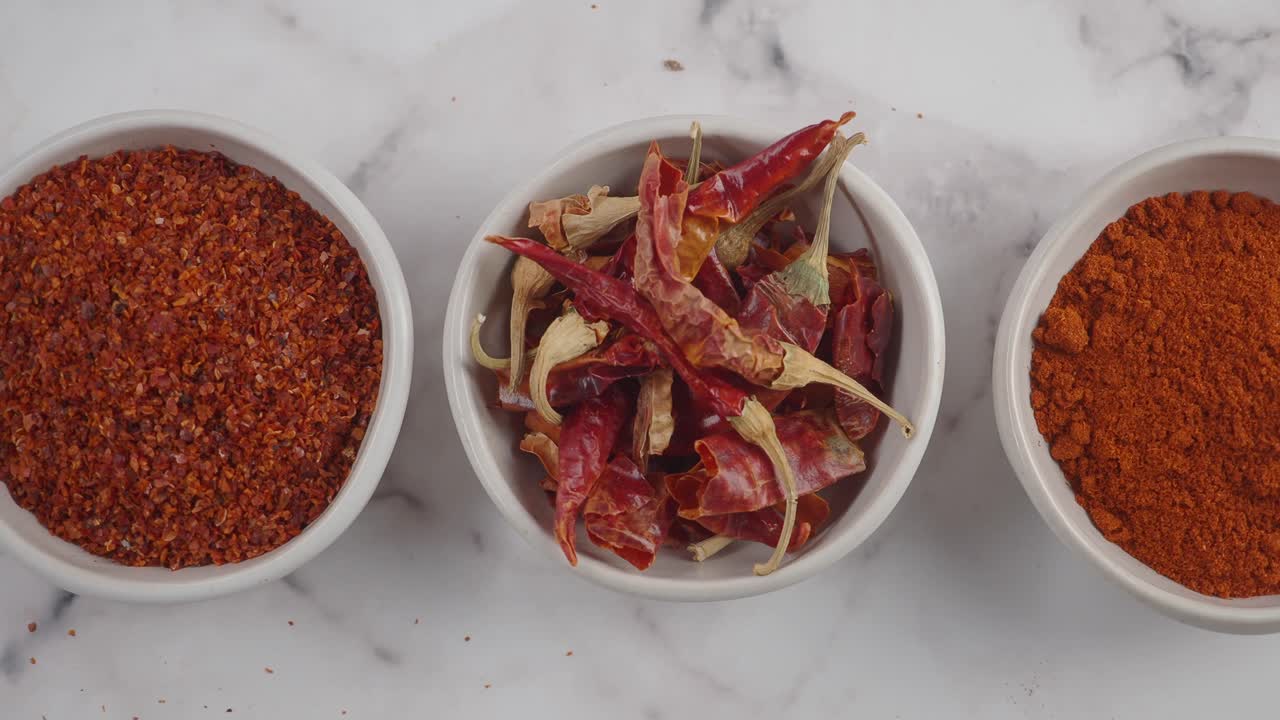 Variety of Chili Spices in Bowls on Marble Surface