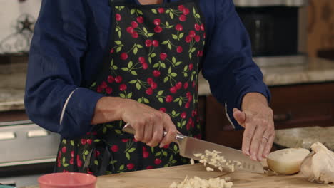 woman chopping garlic with a knife in slow motion