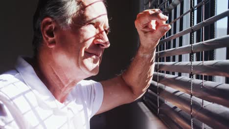 hombre mayor mirando a través de la ventana 4k