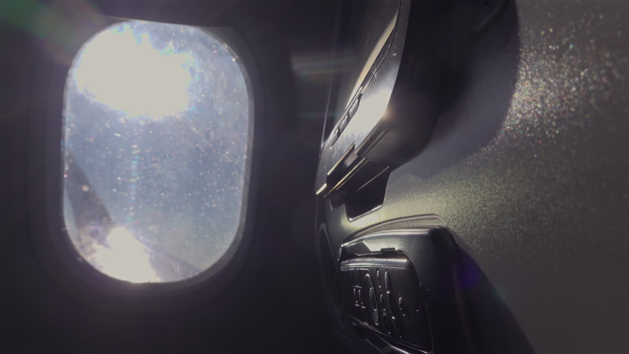 View of the back of a seat and the window of an airplane
