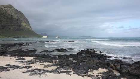 Slow-pan-across-sand-and-ocean-waves