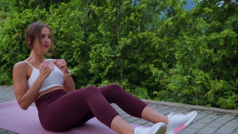 mujer haciendo abdominales al aire libre