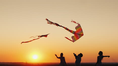 Two-Children-With-Mom-Play-Kites-At-Sunset-Good-Time-Together