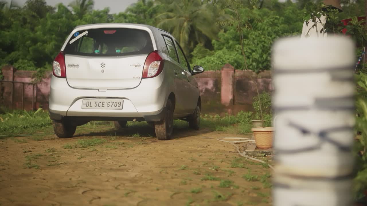 캐주얼한 옷을 입은 여자가 집으로 가는 길을 걸어서 개  ⁇ 줄을 들고 있습니다.